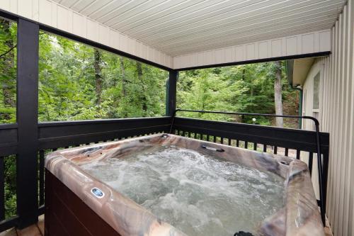 a hot tub on the balcony of a house at Cedar Falls by Eden Crest in Pigeon Forge