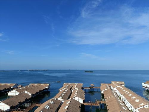 a group of houses in the water with a sky at PD Seaview Sunset Premium Tower Private Suite in Port Dickson