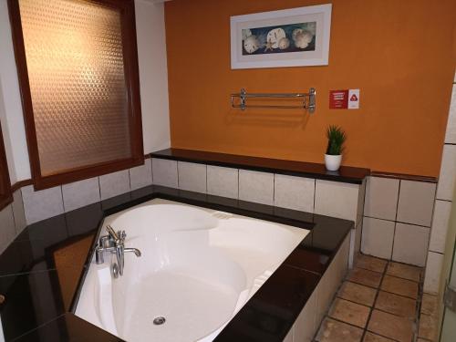 a bathroom with a large white bath tub at PD Seaview Sunset Premium Tower Private Suite in Port Dickson