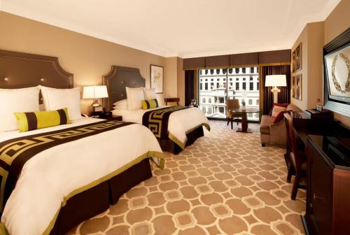 a hotel room with two beds and a television at Caesars Palace Las Vegas by Suiteness in Las Vegas