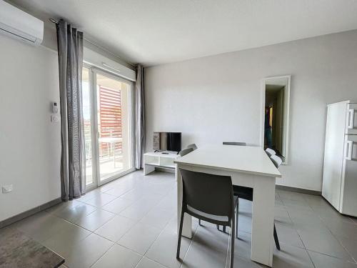 - une cuisine blanche avec une table et une chaise dans l'établissement 3472-Appartement 6 couchages avec piscine, à Argelès-sur-Mer