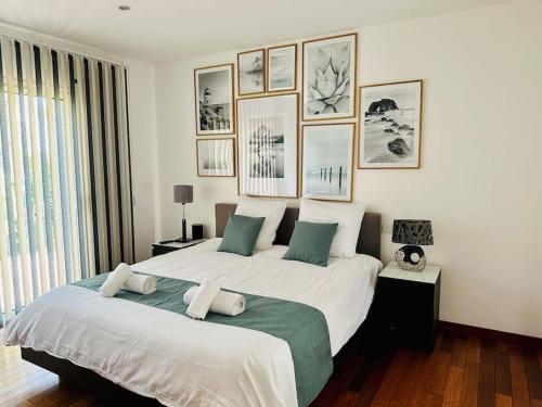 a bedroom with a large bed with pictures on the wall at Villa rospico, 200m de la plage avec piscine in Névez