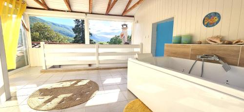 a bathroom with a tub and a large window at La Belle Maison in Avèze