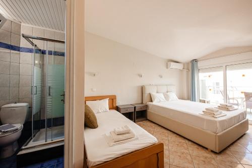 a bedroom with a bed and a bathroom with a shower at Hotel Marialena in Potos
