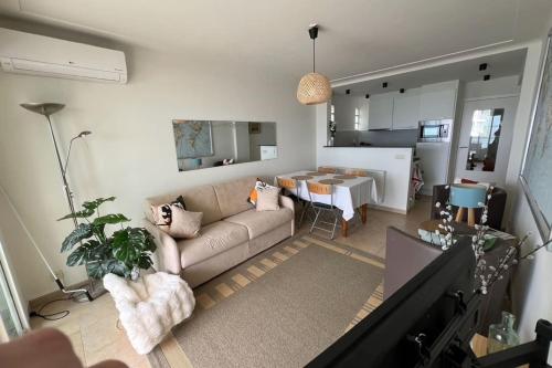 un salon avec un canapé et une table dans l'établissement Comfortable apartment with nice sea view, à Antibes