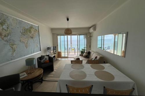 un salon avec une table avec des chaises et un canapé dans l'établissement Comfortable apartment with nice sea view, à Antibes