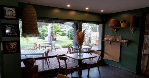 ein Esszimmer mit einem Tisch und Stühlen sowie eine Terrasse in der Unterkunft Les Jardins de L'Ocean - Climatisé in Biscarrosse-Plage