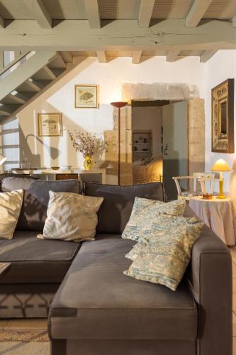 - un salon avec un canapé et des oreillers dans l'établissement Moulin du Meunier - 18th Century Magnificently restored Mill, à Orthoux-Sérignac-et-Quilhan