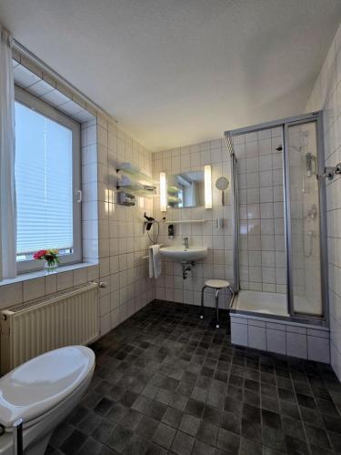 a bathroom with a toilet and a shower and a sink at Hotel Samson in Beckum