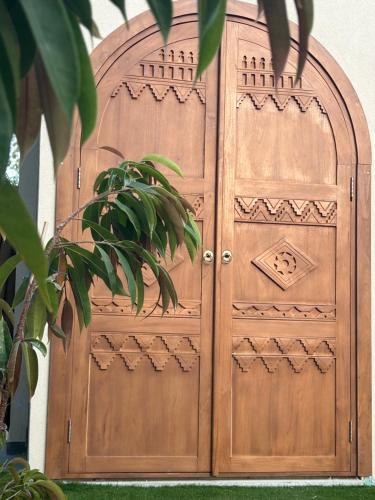 a wooden door in a building with a plant at Exotic Sea Boutique Adults Only in Protaras