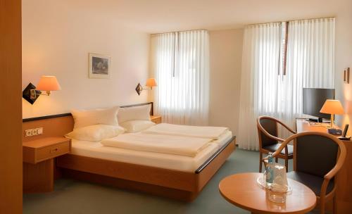 a small hotel room with a bed and a table at Hotel Samson in Beckum