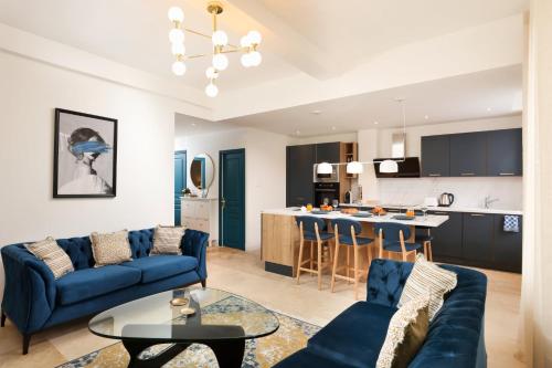 un salon avec des canapés bleus et une cuisine dans l'établissement L'art de Gambetta ConciergerieDameCarcas, à Carcassonne