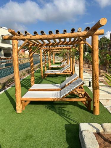a wooden gazebo with books on the grass at Exotic Sea Boutique Adults Only in Protaras