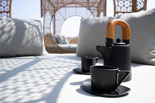 a table with two coffee cups and an umbrella at Exotic Sea Boutique Adults Only in Protaras