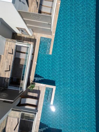 a swimming pool in the middle of a house with a blue floor at Exotic Sea Boutique Adults Only in Protaras