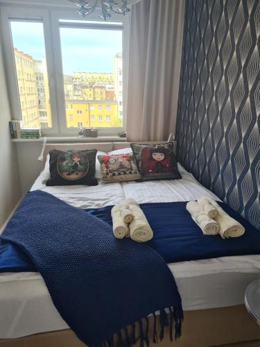 una camera da letto con un letto, asciugamani e una finestra di Lustrzany Skwer a Gdynia