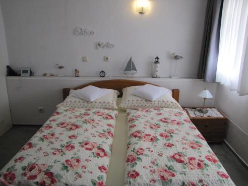 a bedroom with two beds with a floral bedspread at Haus Roseneck Seebad Ückeritz auf Insel Usedom Vermietung im Bereich Souterrain ! in Ueckeritz