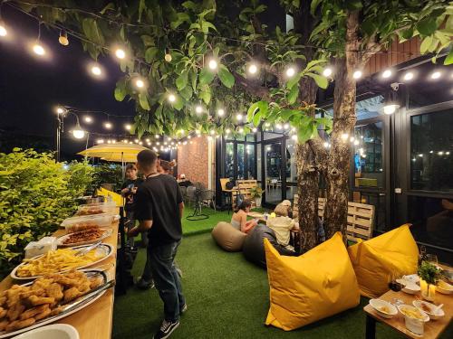 a group of people sitting around a table with food at Wayha Hostel Don Mueang Airport in Bangkok