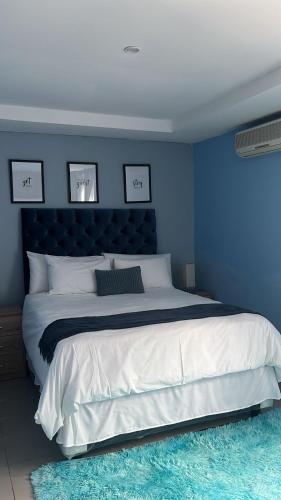 a blue bedroom with a large bed with a blue wall at Mo'Acress Lifestyle in Temba