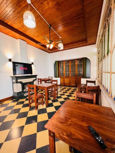 a room with tables and chairs and a piano at HOSTEL COLIVING STUDIO JUNIN in Junín