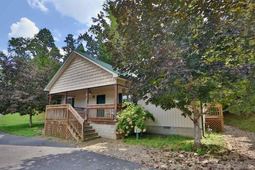 a small house with a porch and a tree at Cherry Blossom by Eden Crest in Pigeon Forge