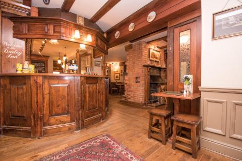 a large room with a bar with wooden cabinets at The Burley Inn in Burley