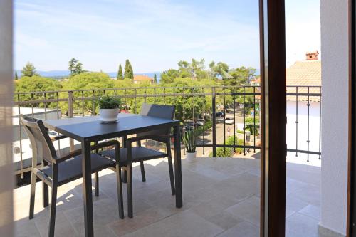 a table and chairs on a balcony with a view at Bracera Inn in Malinska
