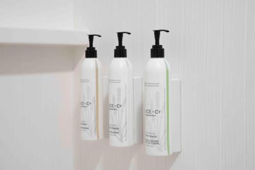 a group of three shampoo bottles sitting on a shelf at Fairfield by Marriott Inn & Suites Annapolis in Annapolis