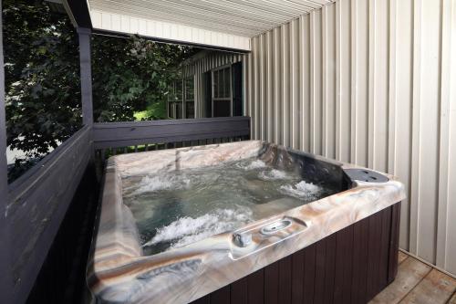 a hot tub on the side of a house at Cherry Blossom by Eden Crest in Pigeon Forge