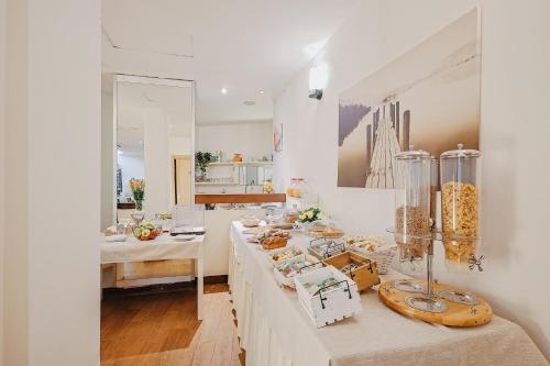 Una habitación blanca con una mesa con comida. en Bi Hotel en Porto Ercole