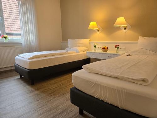 a hotel room with two beds and a window at Hotel Samson in Beckum