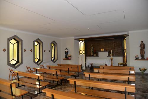 a church with wooden benches and a altar at Il Romitello in Rome