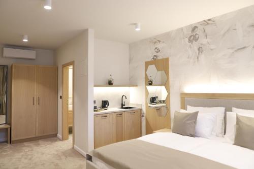 a bedroom with a white bed and a kitchen at Bracera Inn in Malinska