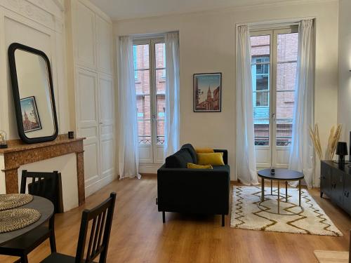 a living room with a couch and a fireplace at LES CARMES - Centre ville Toulouse in Toulouse