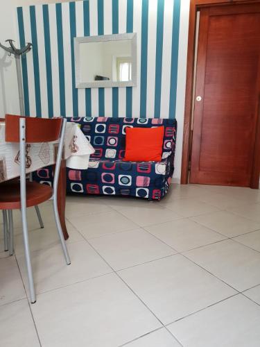een kamer met een tafel, een stoel en een muur bij Nonna Rosa in Margherita di Savoia