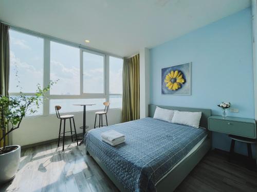 a bedroom with a bed and a table with chairs at Hanoi Home 2 - Lake View Apartment in Hanoi