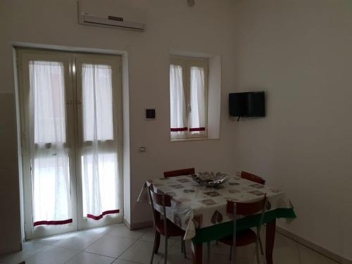 a dining room with a table with chairs and a television at Nonna Rosa in Margherita di Savoia