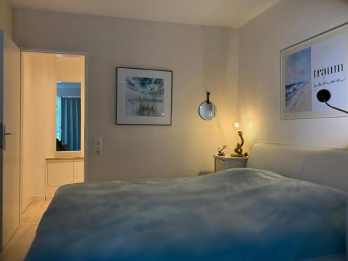 1 dormitorio con cama, lámpara y ventana en Duhnentraum direkt am Sandstrand, Zentrum, Balkon, Meerblick, Parkplatz, Aufzug, Wlan Netflix uvm, en Cuxhaven