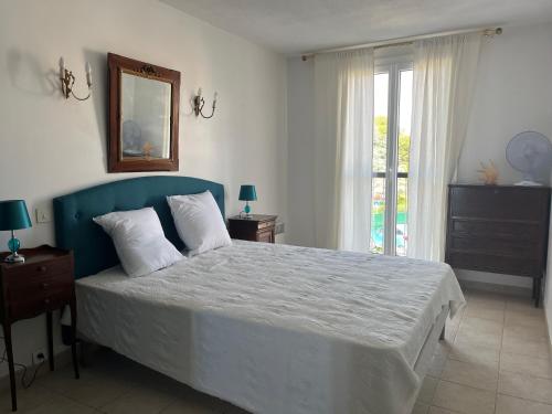 une chambre avec un grand lit avec une tête de lit bleue dans l'établissement Les Lavandes, à Saint-Cyr-sur-Mer