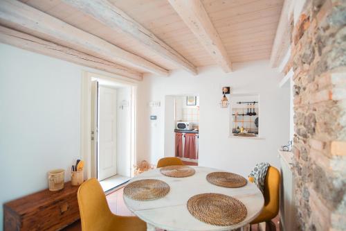 a dining room with a white table and chairs at Casa Antica Pietra Spilimbergo in Spilimbergo