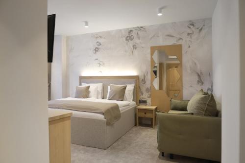 a bedroom with a bed and a chair and a mirror at Bracera Inn in Malinska
