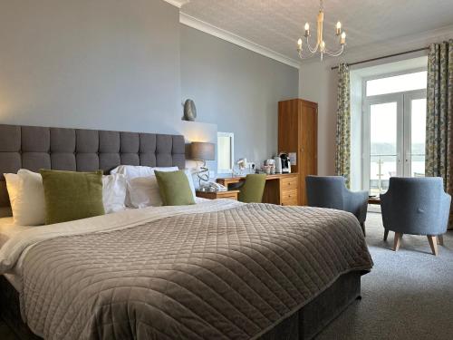 a bedroom with a large bed with a large window at The Cliff Hotel & Spa in Cardigan