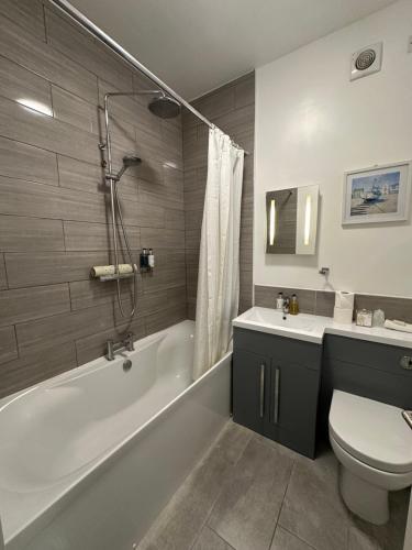 een badkamer met een bad, een toilet en een wastafel bij The Cliff Hotel & Spa in Cardigan