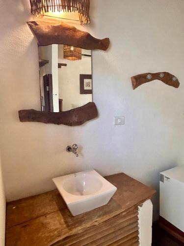 a bathroom with a sink and a mirror on the wall at Pousada Maresia in Atins