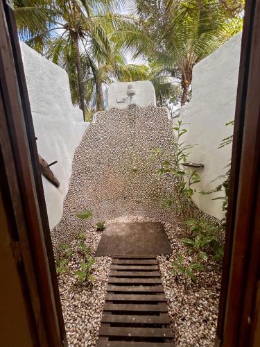 a stairway leading into a garden with palm trees at Pousada Maresia in Atins