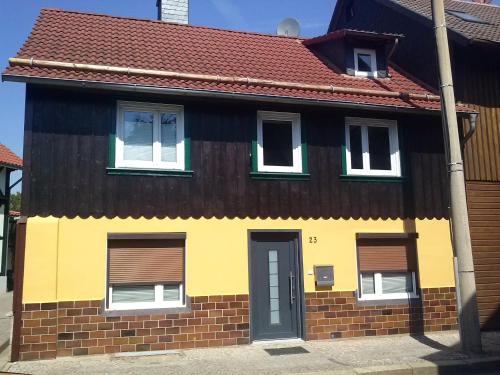 een geel en bruin huis met een rood dak bij Ferienwohnung Schreiberstraße in Wernigerode