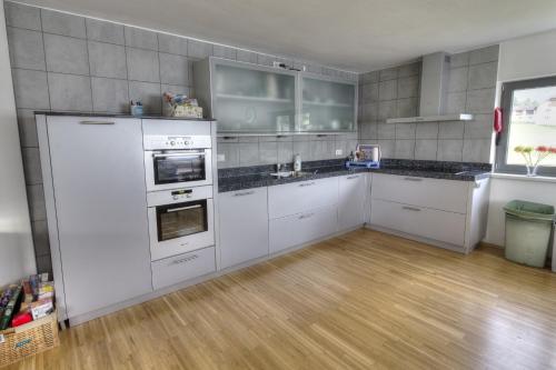 a kitchen with white appliances and a wooden floor at Haus Johendre in Rennweg