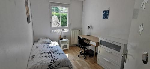 - une petite chambre avec un lit et un bureau dans l'établissement Appartement Le Palladio, à LʼIsle-Adam