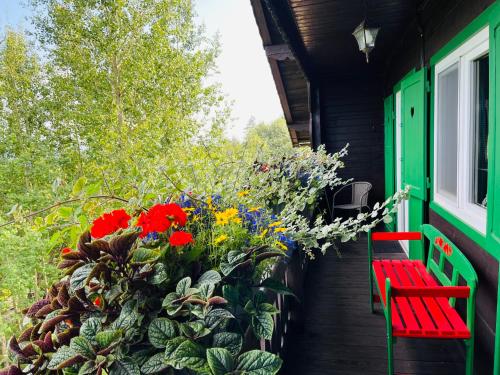 a porch with two red benches and a bunch of flowers at Danielov dom in Vysoké Tatry