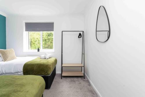 - une chambre avec 2 lits et un miroir mural dans l'établissement Sleeps 4 Monthly Discount WIFI Free Parking, à Borehamwood